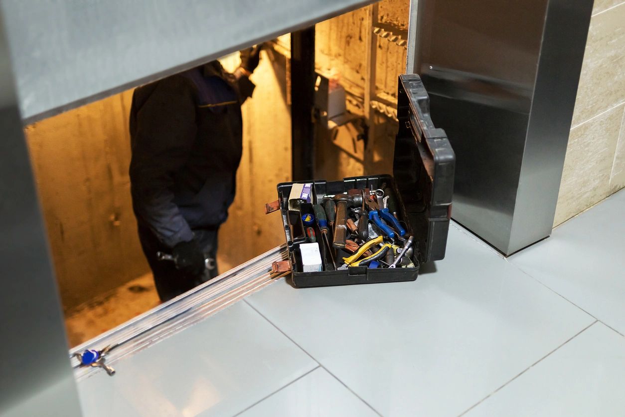 man repairing elevator with tools